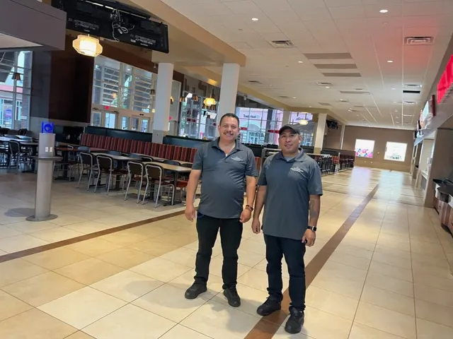 Two Skyward janitorial crew members in a cleaned commercial concourse