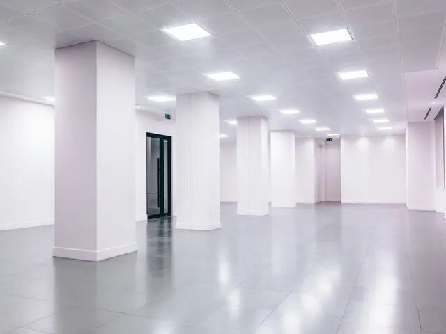Empty white open-plan floor with columns and a polished floor, ready for handover